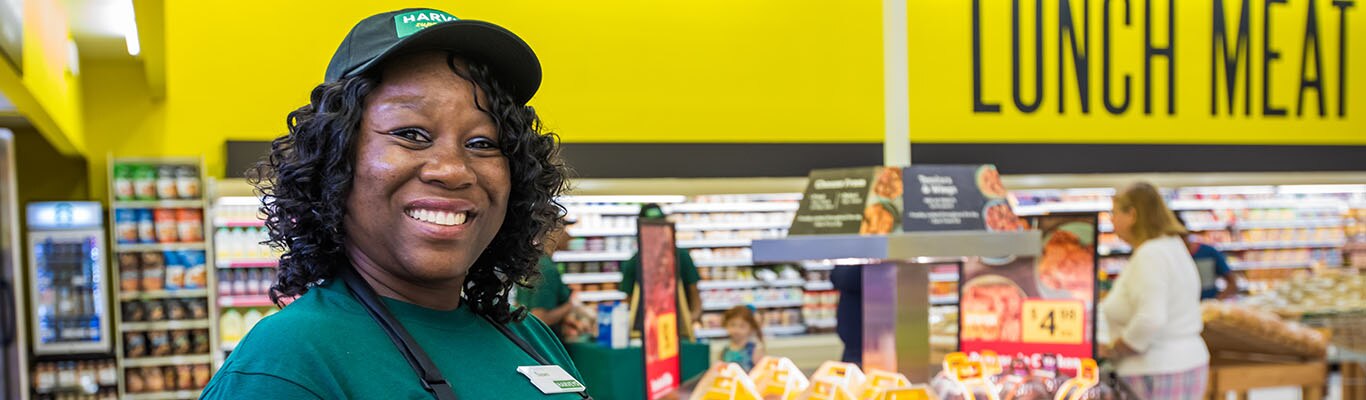 Smiling cashier woman inside grocery store