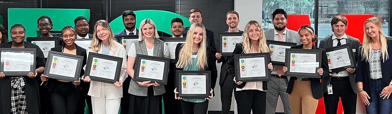 Group of happy Southeastern Grocers' interns holding their certificates. 