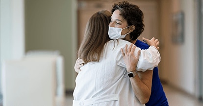 Two physicians joyfully embracing. 