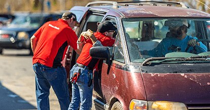 Winn-Dixie associate embracing impacted local resident in car while another associate assists with packing essentials inside the vehicle.