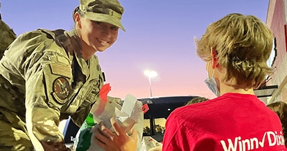 Winn-Dixie gives foundation volunteer helping military service member with placing groceries in car.