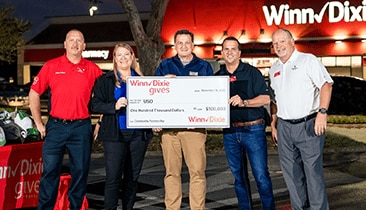SEG and USO members holding a large-sized $100,000 check.