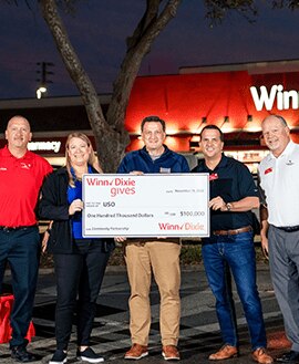SEG and USO members holding a large-sized $100,000 check.
