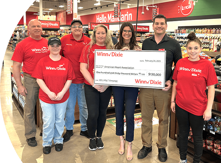 Group of Winn-Dixie employees inside of a store holding a check for the American Heart Association