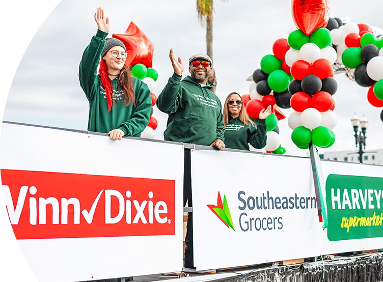 Participants at the Dr. Martin Luther King, Jr. Memorial Foundation Holiday Grand Parade joyfully smiling and waving.