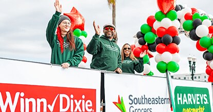 Participants at the Dr. Martin Luther King, Jr. Memorial Foundation Holiday Grand Parade joyfully smiling and waving.