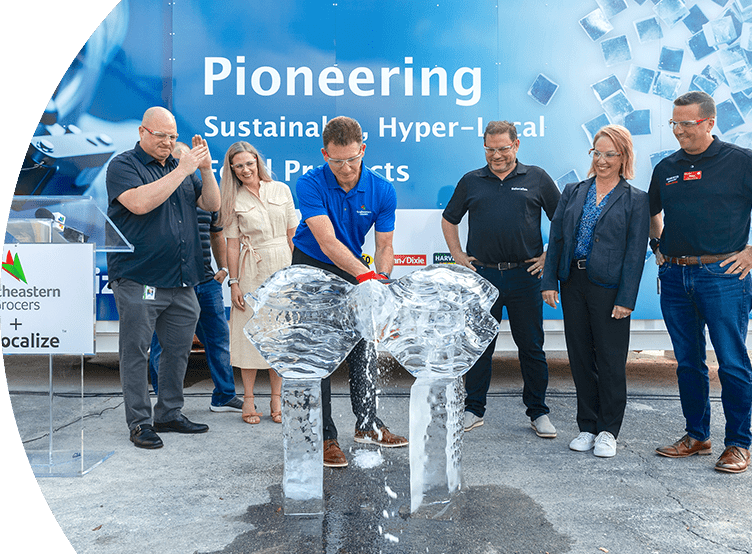 Man cutting ice while group of people around him watch.