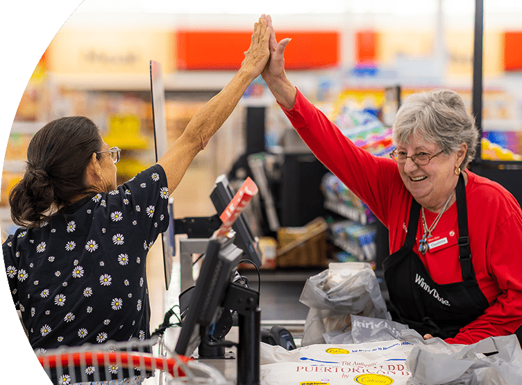 Winn-Dixie cashier joyfully high-fiving customer.