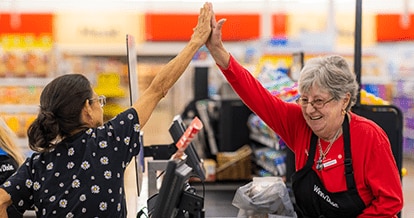 Winn-Dixie cashier joyfully high-fiving customer.