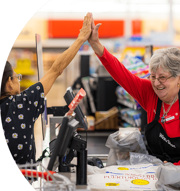 Winn-Dixie cashier joyfully high-fiving customer.