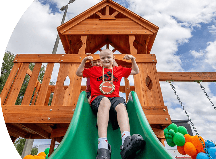 Child smiling going down a slide