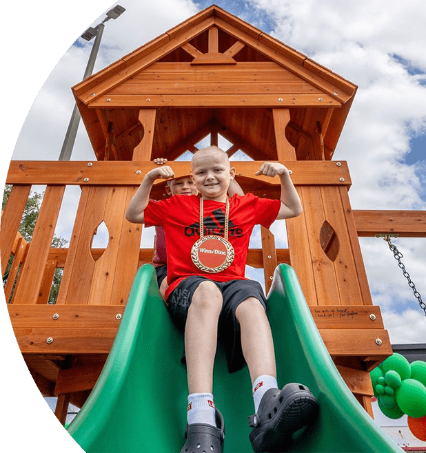 Child smiling going down a slide