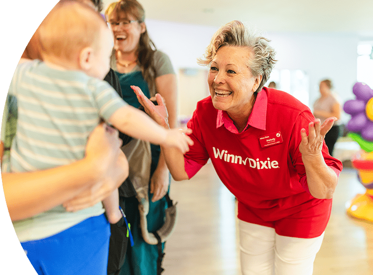 Volunteer smiling at a cheerful baby.