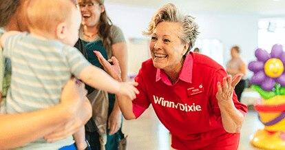 Volunteer smiling at a cheerful baby.