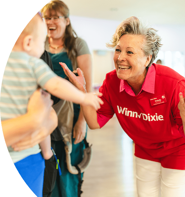 Volunteer smiling at a cheerful baby.