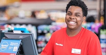 Smiling Winn-Dixie cashier standing behind the cash register machine.