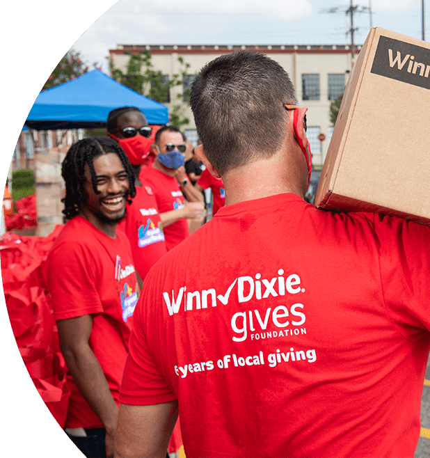 Winn-Dixie Gives Foundation volunteer carrying a box with donations.