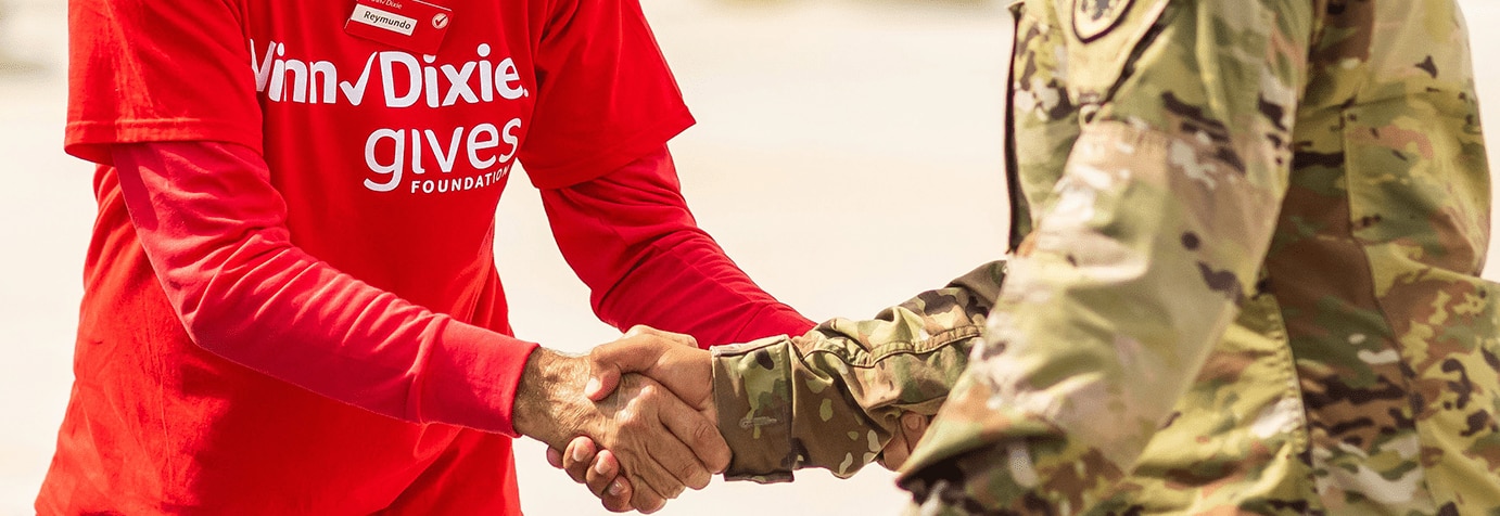 Gives Foundation volunteer shaking hands with veteran.