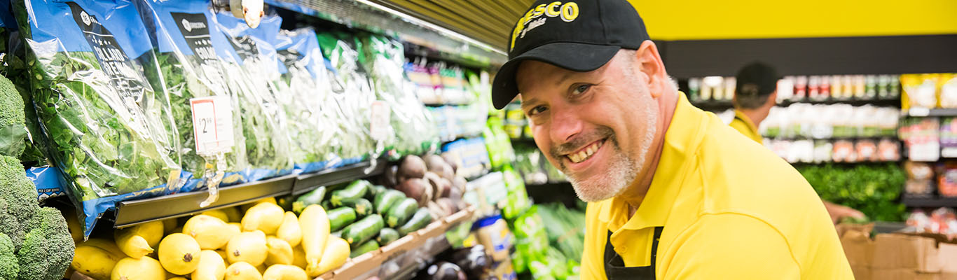 Smiling man stocking produce