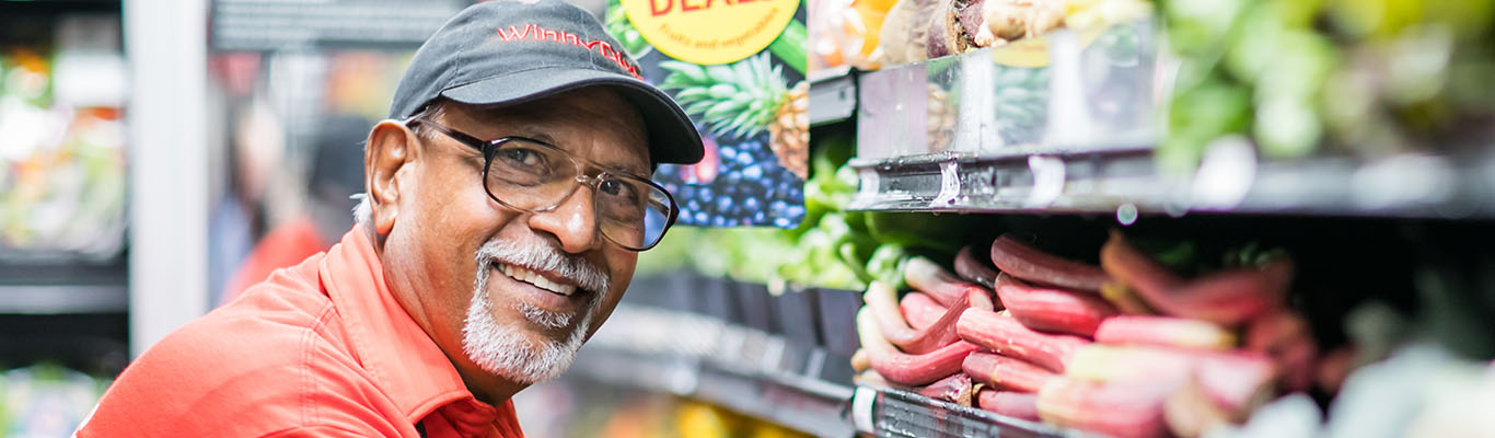 Smiling man stocking produce