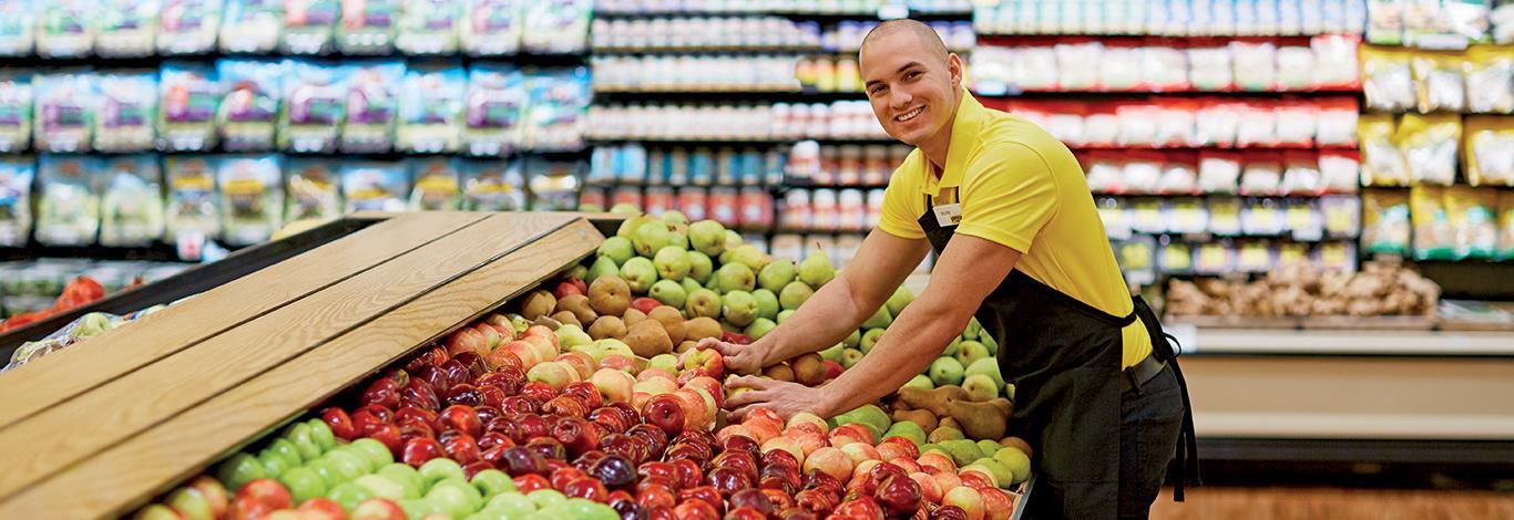 Fresco y Más Produce Associate working in the Produce Department smiling.